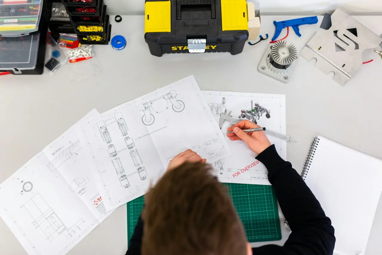 Imagem ilustrativa de um profissional analisando desenhos técnicos em uma bancada